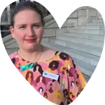 a woman in a bright dress smiling at the camera