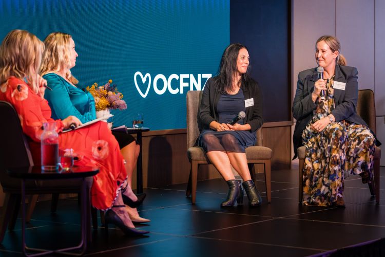 Panelists speaking on stage