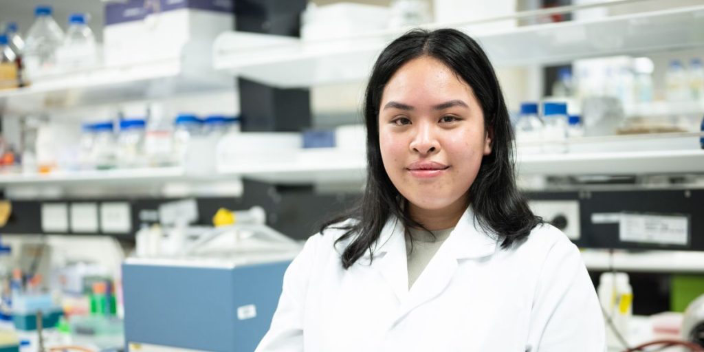 Sonesavanh Larnkham wearing a white jacket standing in a lab