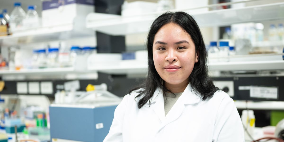 Sonesavanh Larnkham wearing a white jacket standing in a lab
