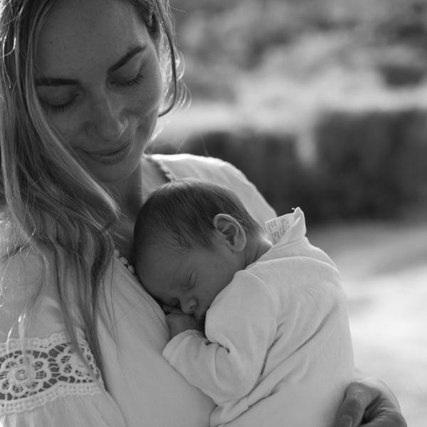 Ablack and white photo of a woman holding her newborn baby
